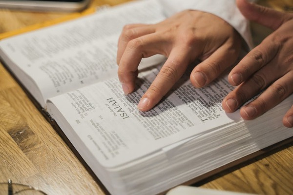Hands moving over Bible pages as the person studies the Bible
