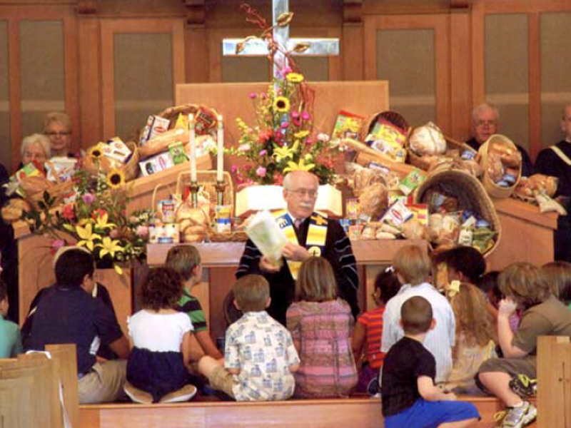 Rev. John Syster talking to a group of children in the church