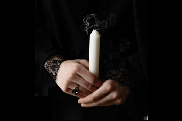 Person holding a candle that has just been extinguished