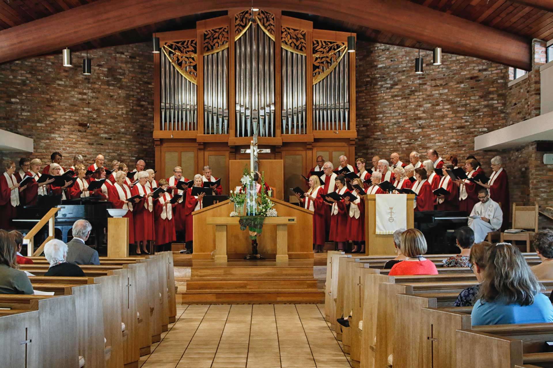 Worship service showing the choir, Pastor Wes Bixby, and the congregation from behind
